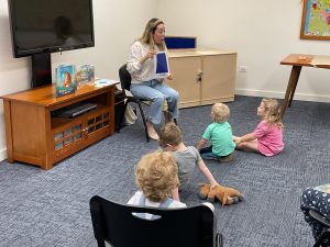 teacher reading to 3 children