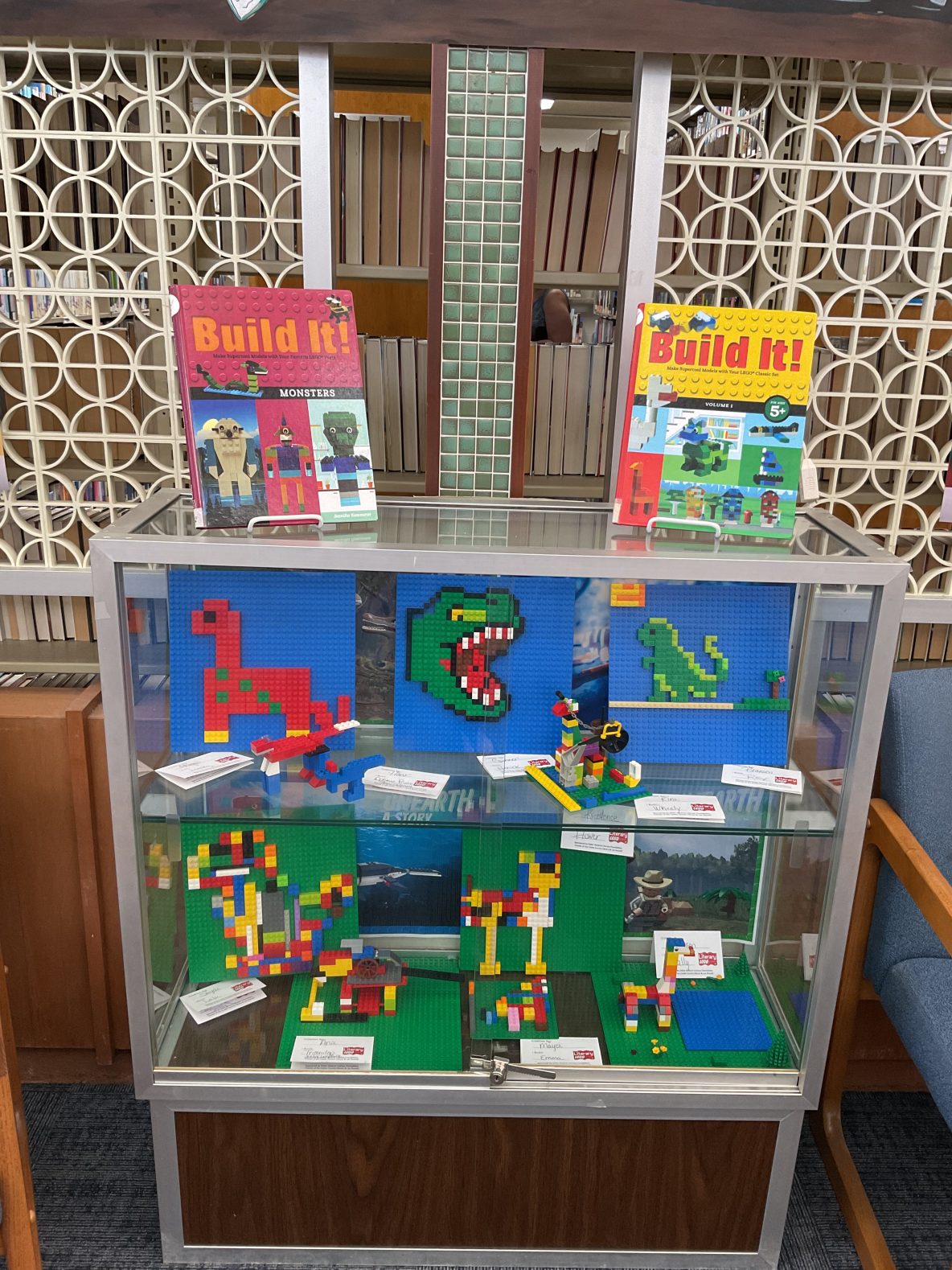 Glass library display case full of mosaic style Lego creations