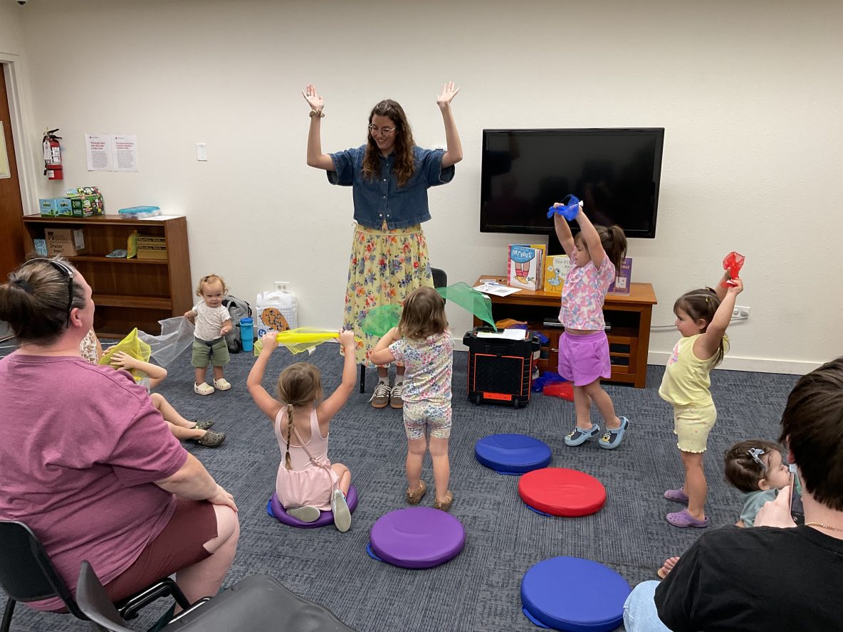 children and librarian sing songs with scarves