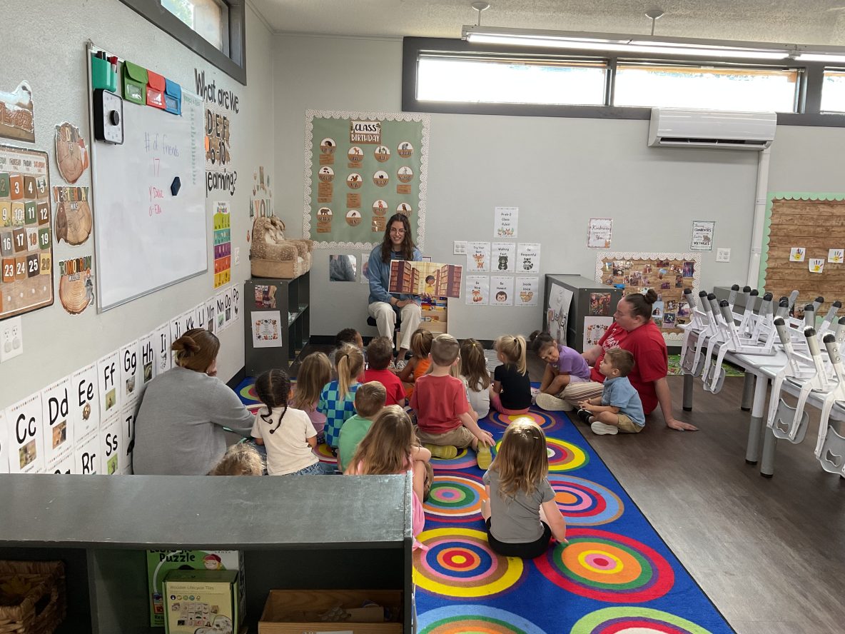 librarian reads to group of seated three year olds at child care center