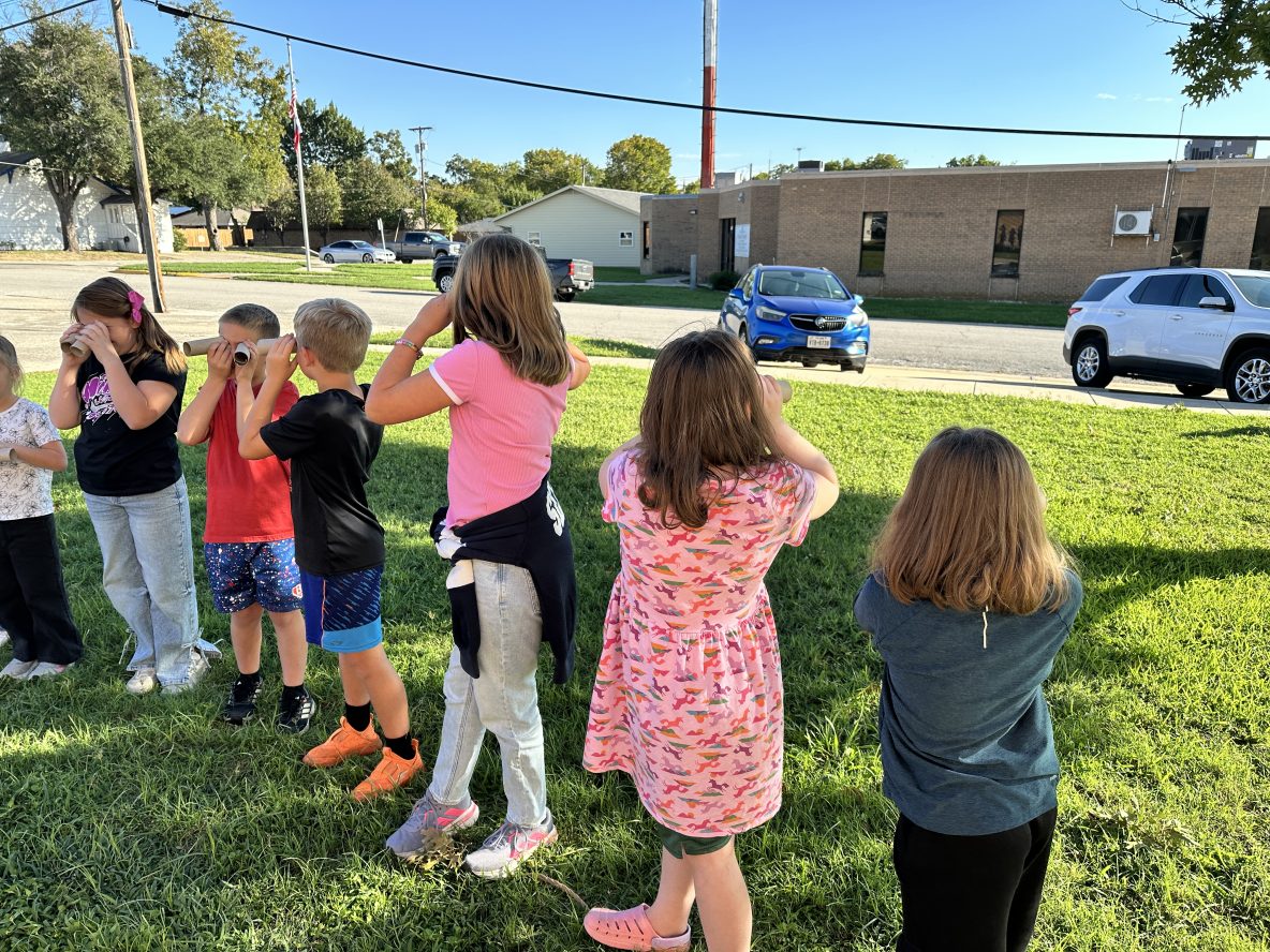 children use paper towel rolls to simulate owl eyes